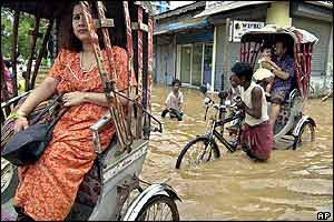 Rickshaw pullers take their customers through floodwaters in Gauhati