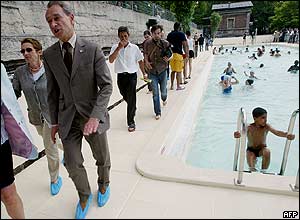 Paris mayor Bertrand Delanoe (left) walks past the new 28-metre pool, part of Paris's most popular summer attraction for the third year running