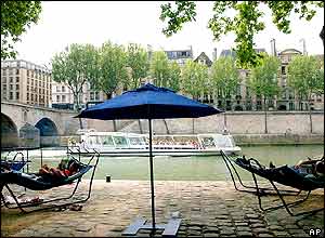 People relax in hammocks at the Paris Plage installation along the River Seine