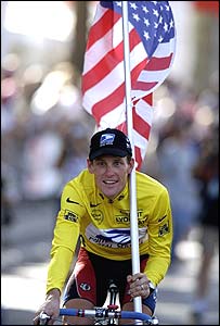 Lance Armstrong cycles round the Champs Elysees with the USA flag after winning the 1999 Tour de France