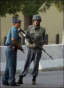 An Uzbek police officer, left, and a sniper stand guard outside the US Embassy