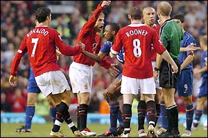 Phil Neville remonstrates with referee Mike Riley and goes on to join brother Gary and Ashley Cole in being booked