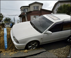 A car is caught in a crack on the road in Nagaoka, northwest of Tokyo, Monday, Oct. 25, 2004. 