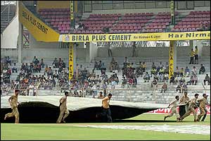 Groundstaff cover the outfield in Mumbai