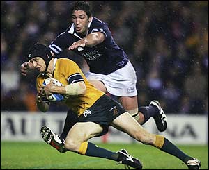 Stephen Larkham is stopped by Nathan Hines 