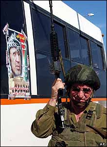 Israeli soldier by Palestinian bus in Nablus