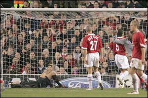 Man Utd's Roy Carroll lies on the turf after letting a goal in