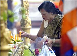 A Lao woman lights a candle at Srimuang pagoda Vientiane, Friday, Nov. 26, 2004