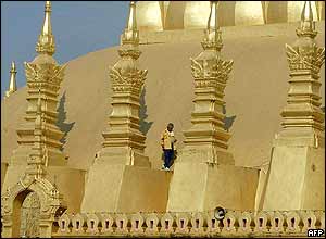 A worker walks along the side of Thatluang shrine, Lao's national symbol, in Vientiane, 25 November 2004. Laos