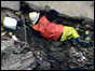 Fireman lying on rubble of Putney flats