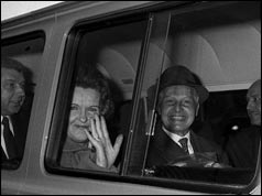 Helen and Peter Kroger in back of van smiling and waving 