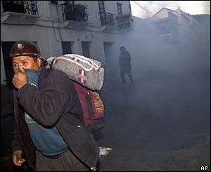 A miner runs away from tear gas fired by police in Sucre