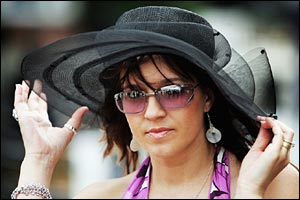 Another lady holds her hat in the wind