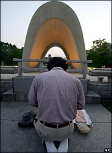 A man prays in front of the Hiroshima cenotaph