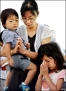 A mother and children pray at Hiroshima Peace Park