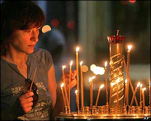 Woman in a St Petersburg church lights a candle for the trapped sailors.