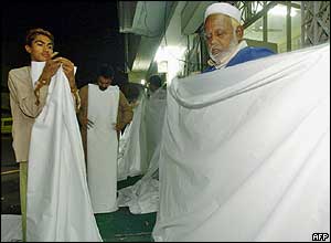 Members of a Pakistani non-governmental organisation, the Edhi Welfare Foundation, prepare burial shrouds for the victims of the 26 December tsunamis at their offices in Karachi