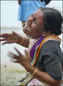A woman cries near the body of her child, unseen, who was killed by tidal waves at Silver Beach in Cuddalore, India, on Monday