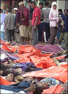 People walk through a temporary morgue in Banda Aceh