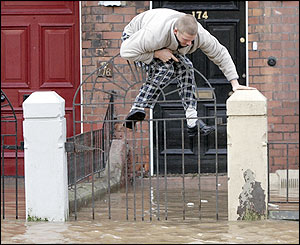 A resident climbs above flood water in Carlisle