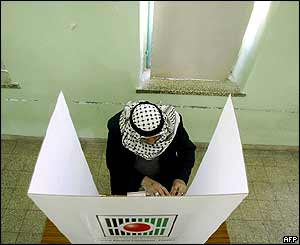 A Palestinian prepares his vote behind a polling booth in the village of Ain Ariq on the outskirts of Ramallah