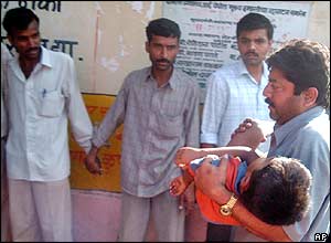 A young boy is carried away on a stretcher
