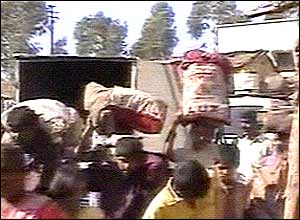 Pilgrims in Wai fleeing the temple complex carrying their belongings
