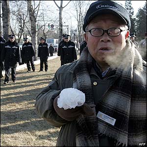 A mourner holds a flower in front of Babaoshan cemetery, Beijing