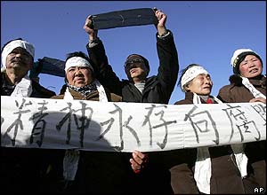 Protesters with a banner reading Ziyang's spirit lives forever, declare war on corruption