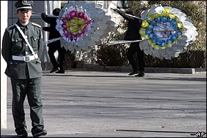 Government workers pack away wreaths after the funeral of Zhao Ziyang