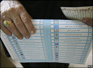 An Iraqi woman holds a ballot paper and her ID