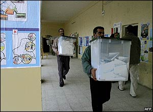 Iraqi election workers in Basra carry ballot boxes