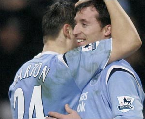 Robbie Fowler is congratulated by Joey Barton after scoring his penalty