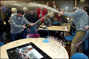 The on-shore team celebrate after MacArthur crosses the finish line