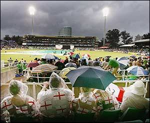 Fans wait for play to resume after the rain