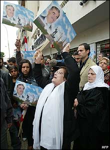 People await the arrival of the ambulance carrying the body of Rafik Hariri outside his Beirut home