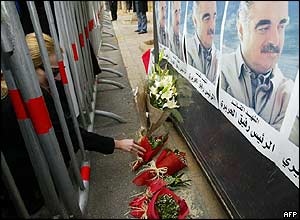 Woman lays flowers at a memorial site outside the Beirut home of former Prime Minister Rafik Hariri 