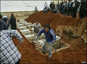 Workers prepare the graves on land adjacent to Muhammad Amin Mosque 