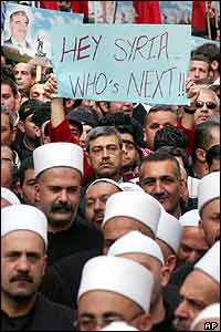 Mourner displays anti-Syrian placard