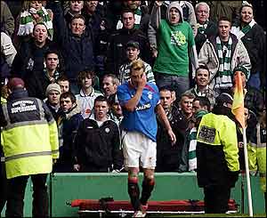 Ricksen appears to be hit by a coin thrown from a spectator as full-time looms