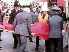 Rescuers loading a stretcher into an ambulance