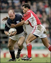 Lawrence Dallaglio (L) is tackled by Brian Lima