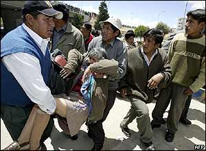 Demonstrators carry away woman affected by tear gas in El Alto in protest against French water consortium