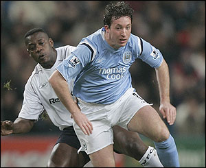 Robbie Fowler is tackled by Bolton's Bruno N'Gotty 