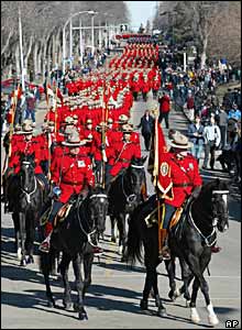 Mounted police lead a march for the dead RCMP officers