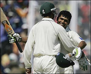 Kamran Akmal raises his bat in celebration