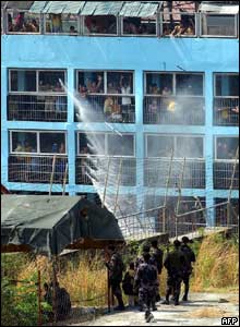 Detainees cheer as a fire truck sprays water on them to lessen the effect of tear gas - 15/3/05