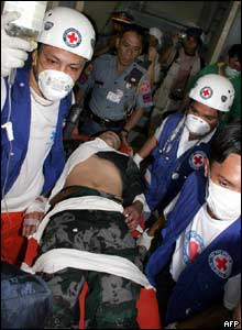 Red Cross staff carry a wounded Filipino policeman - 15/3/05
