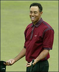 Tiger Woods celebrates his birdie at the last 