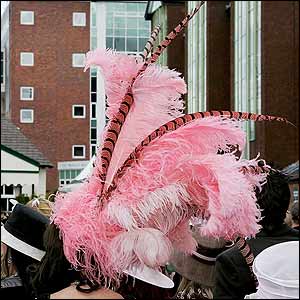 A lady attends Aintree in a pink feathered hat